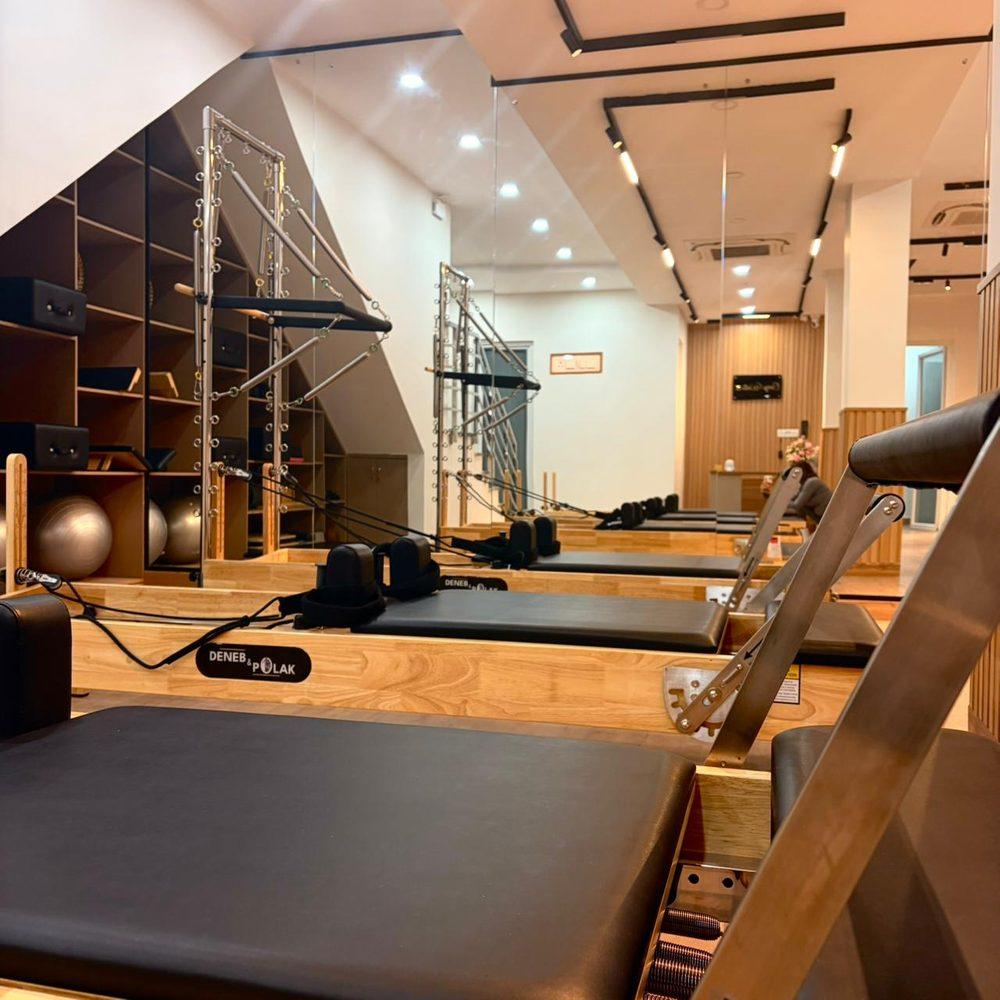 Row of Pilates reformer machines at the Carry Wellness studio